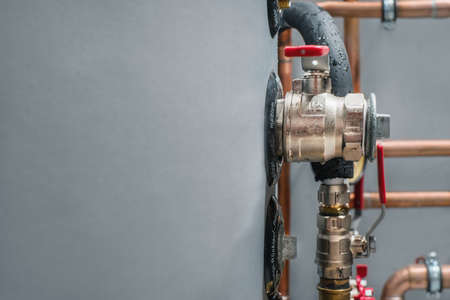 Valves and copper pipes on a boiler in a boiler room. Close up. Space for a text.