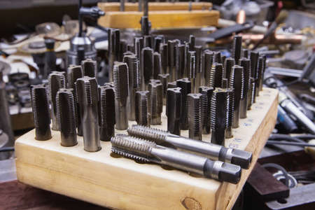 Many taps for making thread in a wooden holder. close upの写真素材