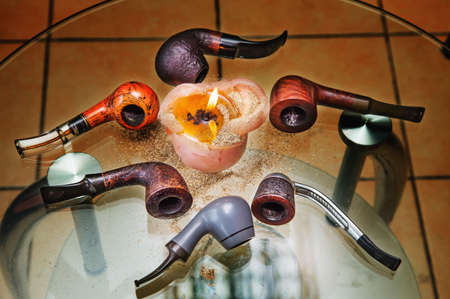 Candle flame and six pipes  on a  glass table. Top view.の写真素材