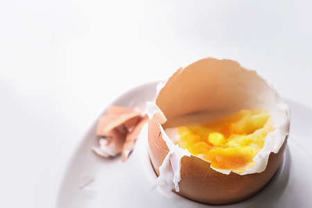 Part of egg in a plate after breakfast. On a white background in macro.