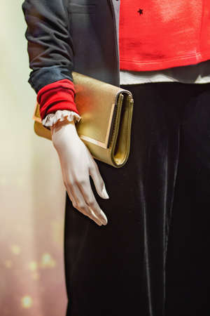Woman mannequin holding golden color handbag. Close up.の写真素材