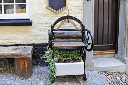 Antique mangle Victorian press with plant in front of house.の写真素材