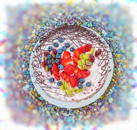 Colorful jelly fruit cake with milk on a white plate in a colorful small stones bancground. Close up.の写真素材