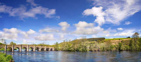 Beautiful panoramic landscape with an old stone bridge on a sunny cloudy day in a county Cork....