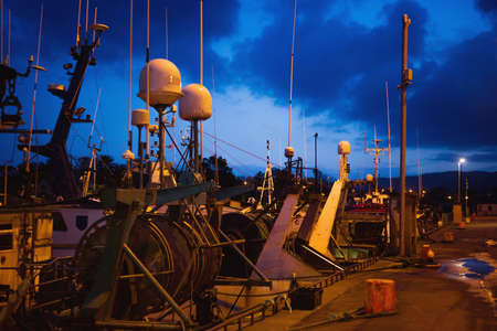 Ships with various antennas at the marina at night.South coast of Ireland.の写真素材