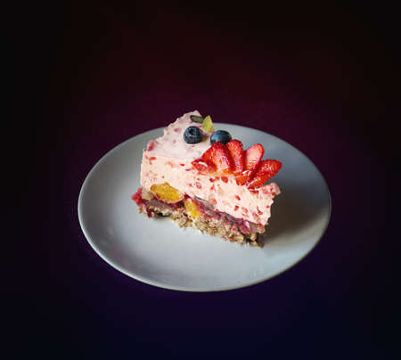 Piece of jelly fruit cake with milk on a white plate. Close up.