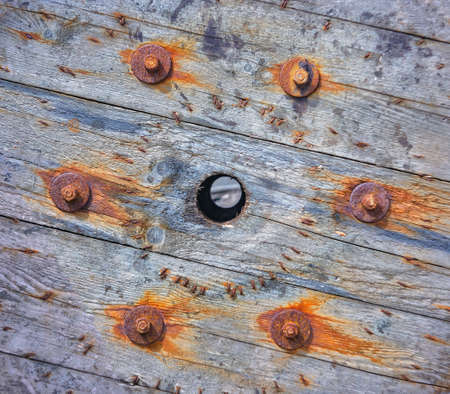 Corroded nut with washer and rusty nails on a wooden surface. Close view.の写真素材