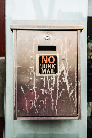 Dirty postbox with the words NO JUNK MAIL. Close view.