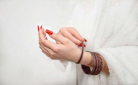 Woman's hands with bracelets on a white background. Close view.