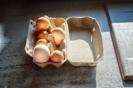 Cardboard case with big and small eggs on a table. Close up.の写真素材
