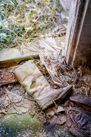 Old soldier's shoe in abandoned and uninhabited house. Close view.の写真素材