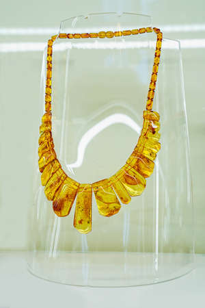 Amber neklace on a glass shelf. Close up.