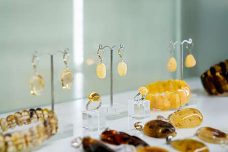 Various amber jewelry on a glass shelf. Close up.の写真素材