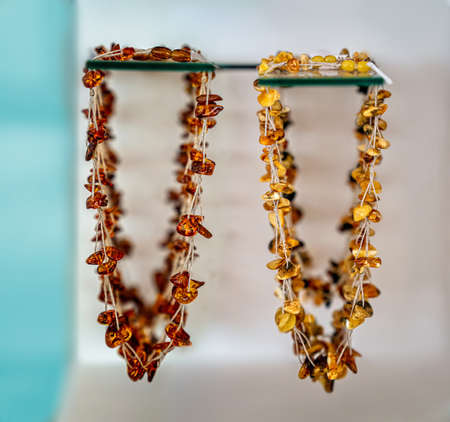 Amber neklaces on a glass shelfs. Close up.の写真素材