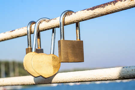 Close view of padlocks on a bridge in a blue sky background