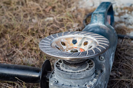 Old angle grinder with disc on a autumn grass.