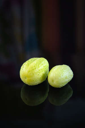 Two cucumbers True Lemon on a dark background. Close up.の写真素材