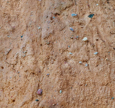 Dry clay and small stones in it. Background.