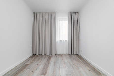 Apartment window with a drape and curtainin themulti-storey house white room.の写真素材