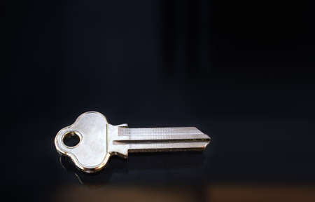 Blank metal key on a dark background. Close up.の写真素材