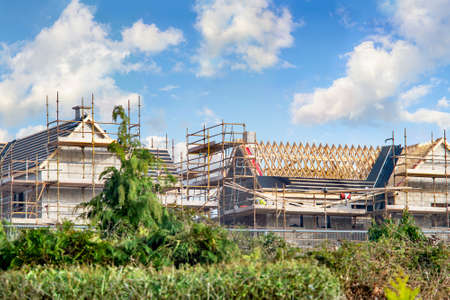 Houses construction with  rafters and scaffoldings on cloudy day. Ireland.