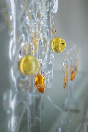 Amber necklace with inclusion on the glass shelf. Close up.の写真素材