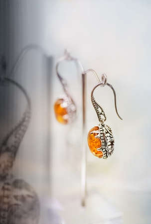Amber earrings on the glass shelf. Close up.の写真素材