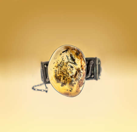 Beautiful silver bracelet with amber on bright gradient backgrounndの写真素材