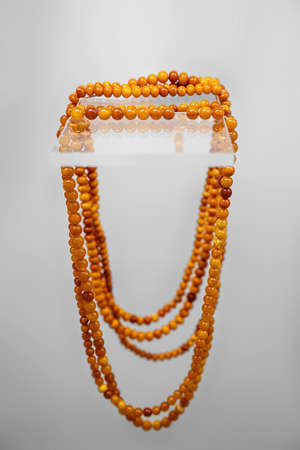 Amber beads on the glass shelf. Close view.の写真素材