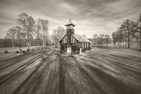 Small wooden church with bell tower in Virsuziglis in spring. Lithuania. Black white.の写真素材
