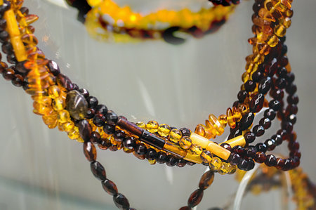 Various amber beads on a glass shelf. Close up.の写真素材