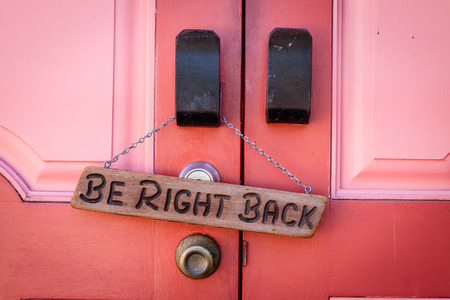 A Be right back sign hanging on the door of a closed businessの写真素材