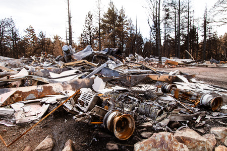 The charred remains of a house after a devastating forest fire