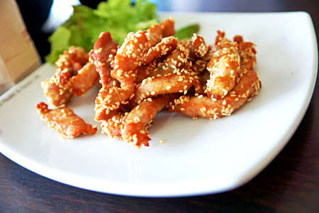 Fried pork with sesame on white plate -Thai cuisineの写真素材