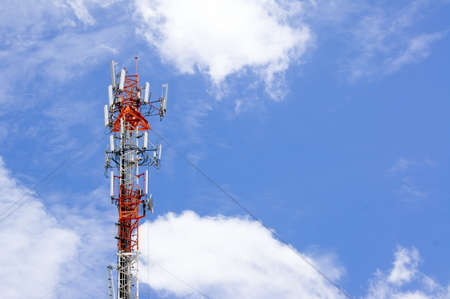 Telecommunication tower against cloudy sky