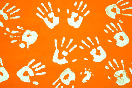 White hands print on orange color wooden sheet backgroundの写真素材