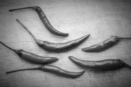 Red chili peppers on old wooden Chopping board background - Black and Whiteの写真素材
