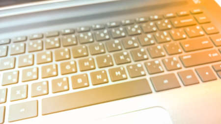 Blurry keyboard with warm light shining as abstract background - Business and Technology Concept
