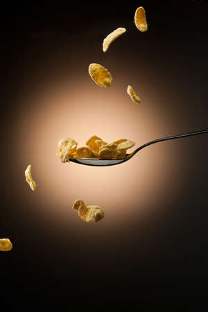 tasty corn flakes are falling down on spoonの写真素材