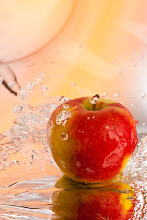 red ripe apple water splash over abstract backgroundの写真素材