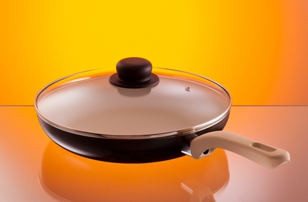 frying pan over hot orange backgroundの写真素材