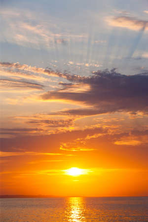 sunset with clouds and rays on the seaの写真素材
