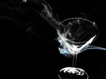 cocktail glass with smoke over black backgroundの写真素材