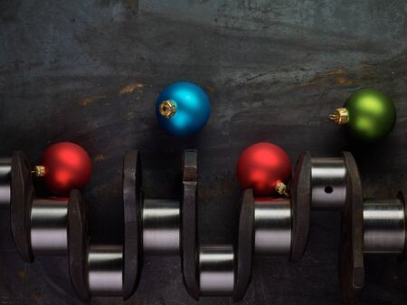 Shiny christmas bulb and crankshaft on the steel table