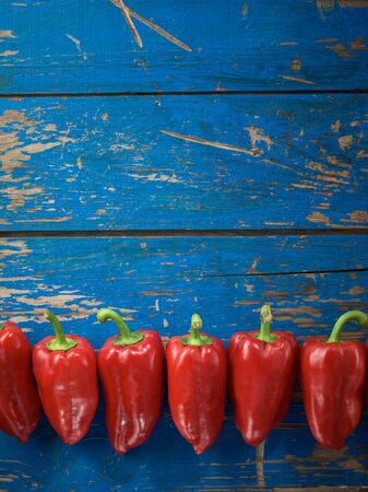 Red tasty pepper on the blue wooden tableの写真素材