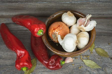 Garlic, red pepper, garlic and bay leaf on wooden backgroundの写真素材