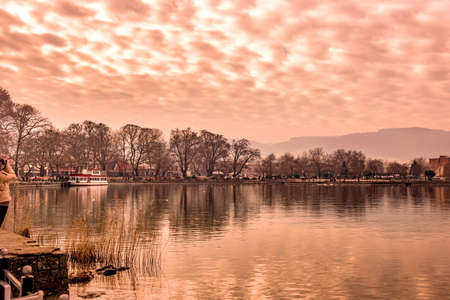 Scenery of Ioannina city lit up by red sunlight  colors  and glowing sky with reflections on the...