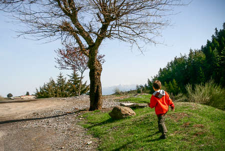Child walking alone at a path on mountain.Greece.の写真素材