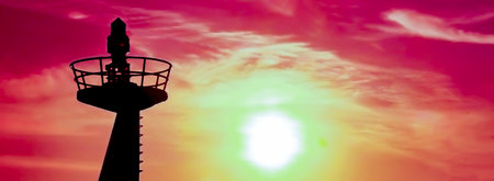 silhouette of lighthouse against a dramatic red skyの写真素材