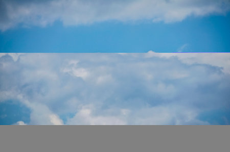 seagull flying high up  between clouds in the sky